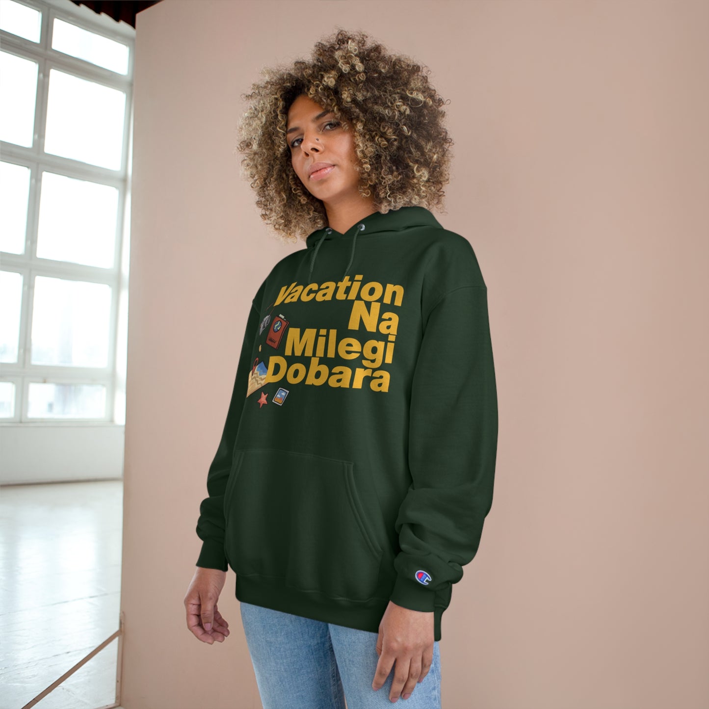 Woman wearing VNMD Champion hoodie in dark green with "Vacation Na Milegi Dobara" graphic, perfect for travel adventures.
