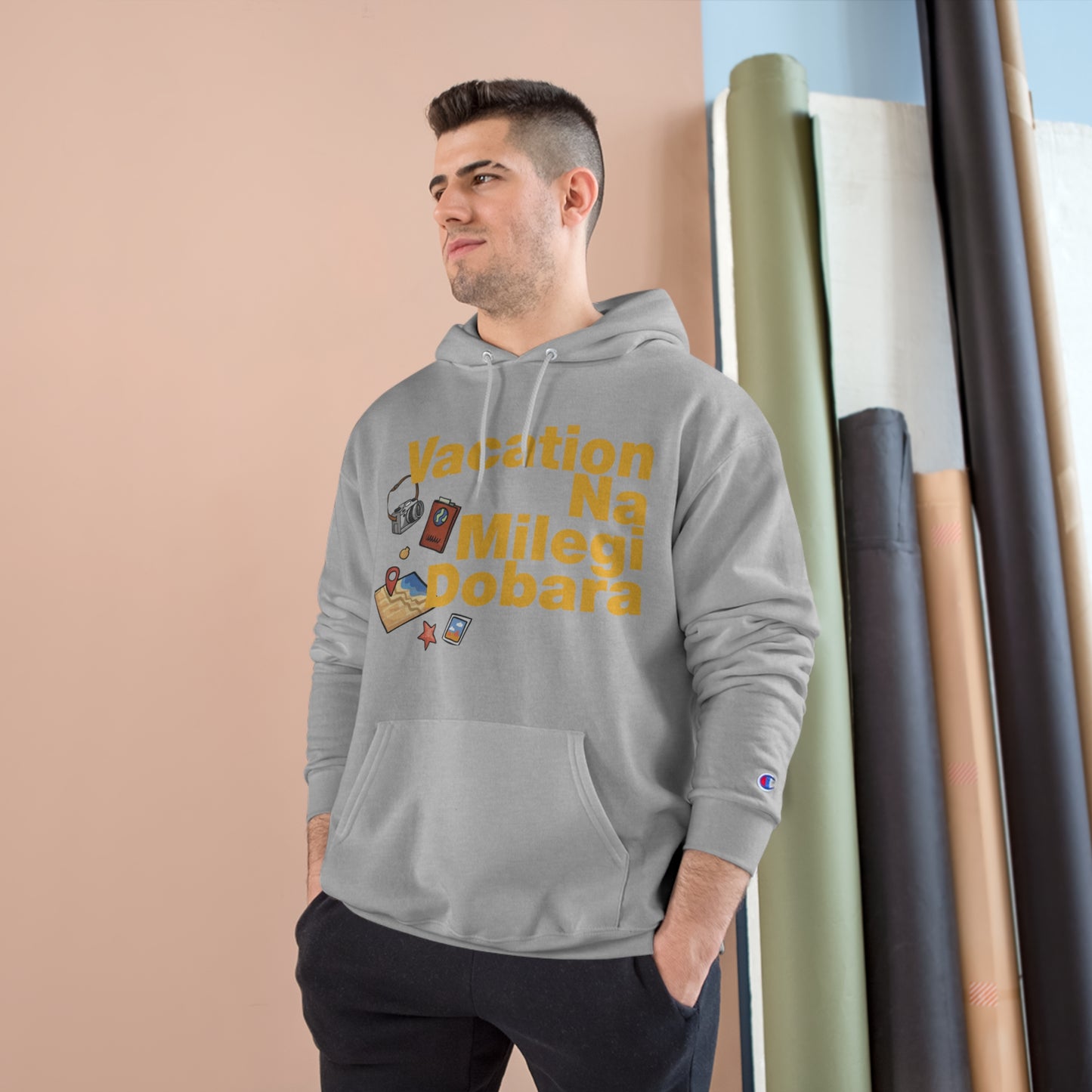 Man wearing a gray Champion hoodie featuring 'Vacation Na Milegi Dobara' text, showcasing a travel-inspired design.