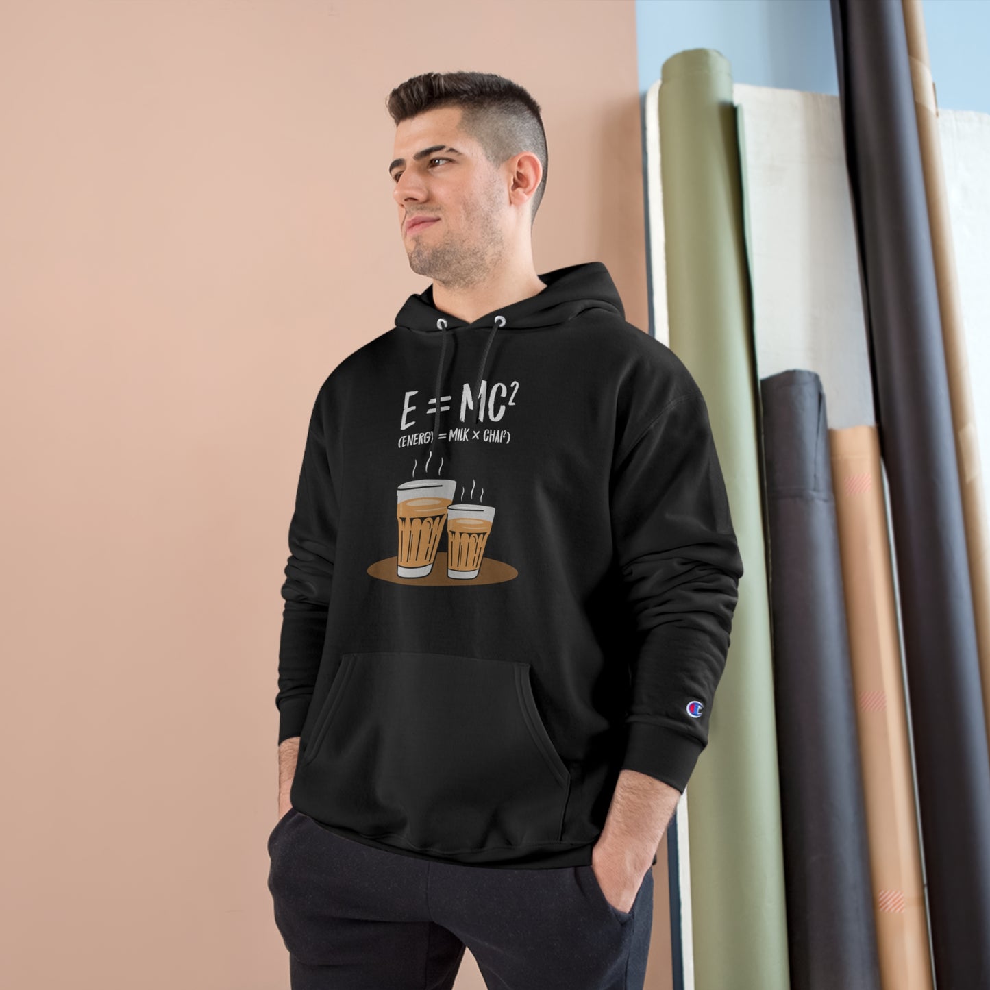 Man wearing E=M*C Champion hoodie featuring chai illustrations, showcasing cozy design and iconic logo.