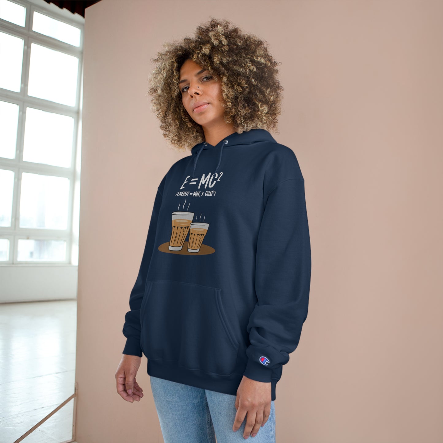 Woman wearing E=M*C Champion Hoodie featuring chai graphics, perfect for chai lovers and cozy comfort.