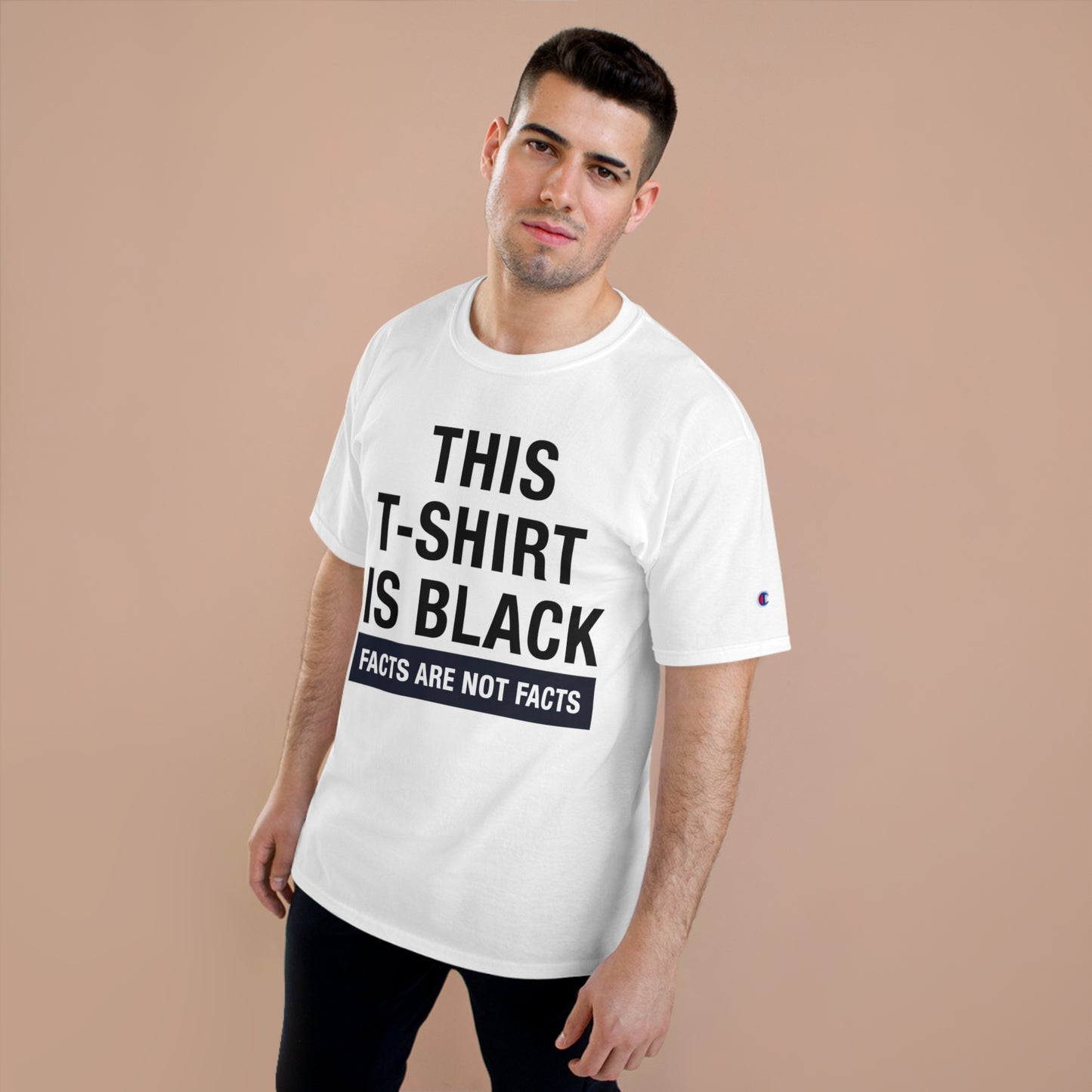 Man wearing oversized white Champion t-shirt with text "THIS T-SHIRT IS BLACK FACTS ARE NOT FACTS" against a neutral background.