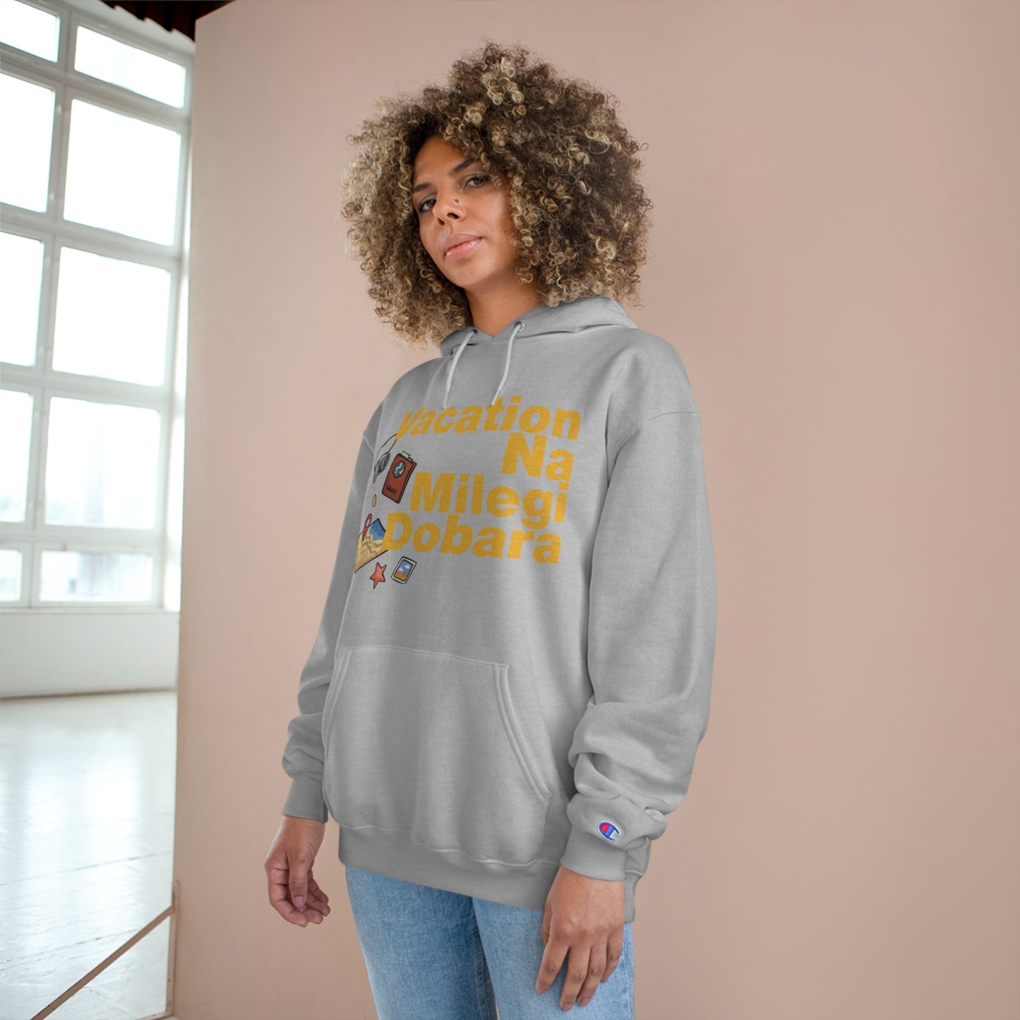 Woman wearing a gray VNMD Champion hoodie with "Vacation Na Milegi Dobara" design in a stylish indoor setting.