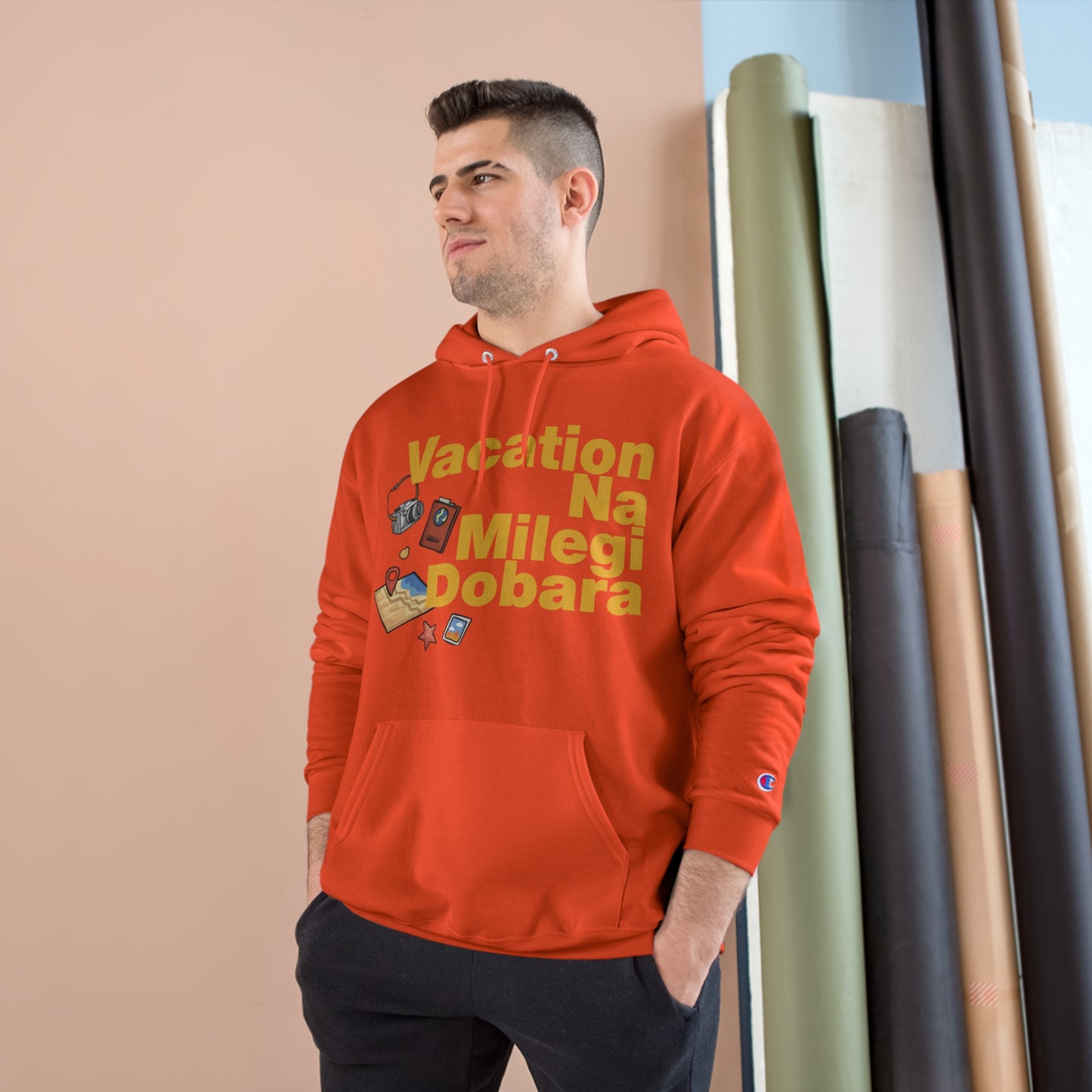 Male wearing red VNMD Champion hoodie with travel-themed graphics, perfect for adventures and cozy warmth.