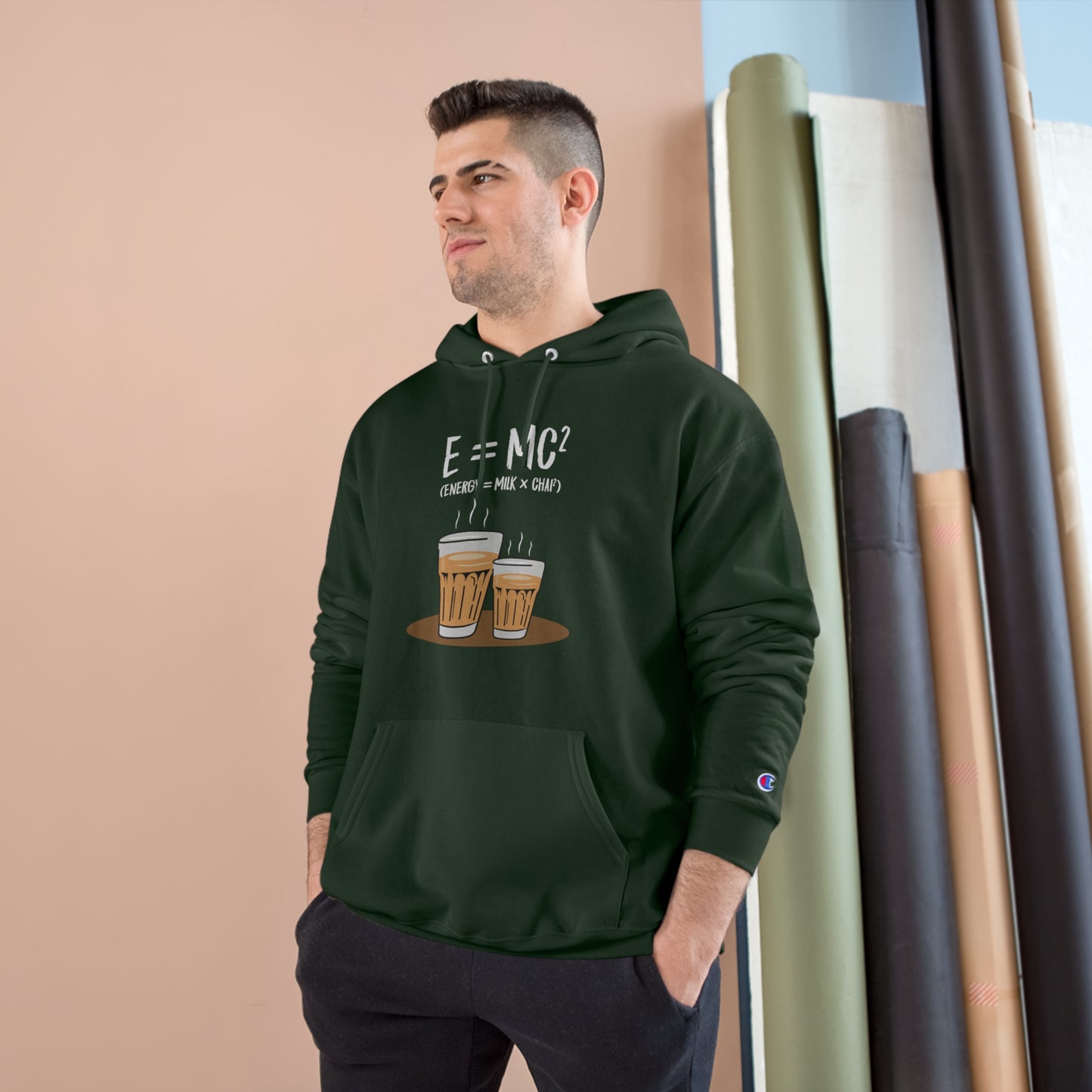 Man wearing E=MC² Champion hoodie featuring chai cups design, showcasing cozy style and warmth.