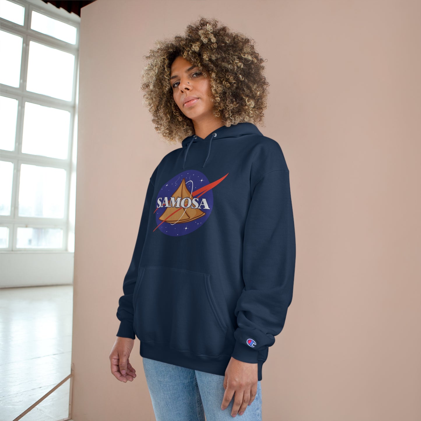 Woman wearing NASA Samosa Champion hoodie, showcasing quirky design and cozy fit in a stylish indoor setting.